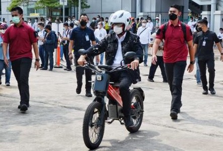 Menteri Perhubungan Budi Karya Sumadi mencoba motor listrik saat mengunjungi pameran kendaraan listrik di Stasiun KA Bekasi Timur, Minggu (18/4/2021).
