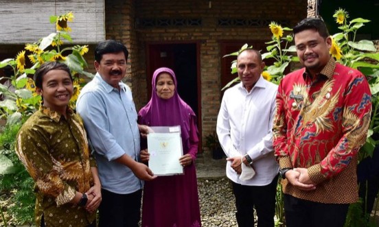 Potret salah seorang warga saat menerima sertifikat dari Menteri ATR/BPN Hadi Tjahjanto di Jalan Keramat Indah, Kelurahan Medan Tenggara, Kecamatan Medan Denai, Kota Medan, Sumatera Utara, Kamis (17/11/2022).