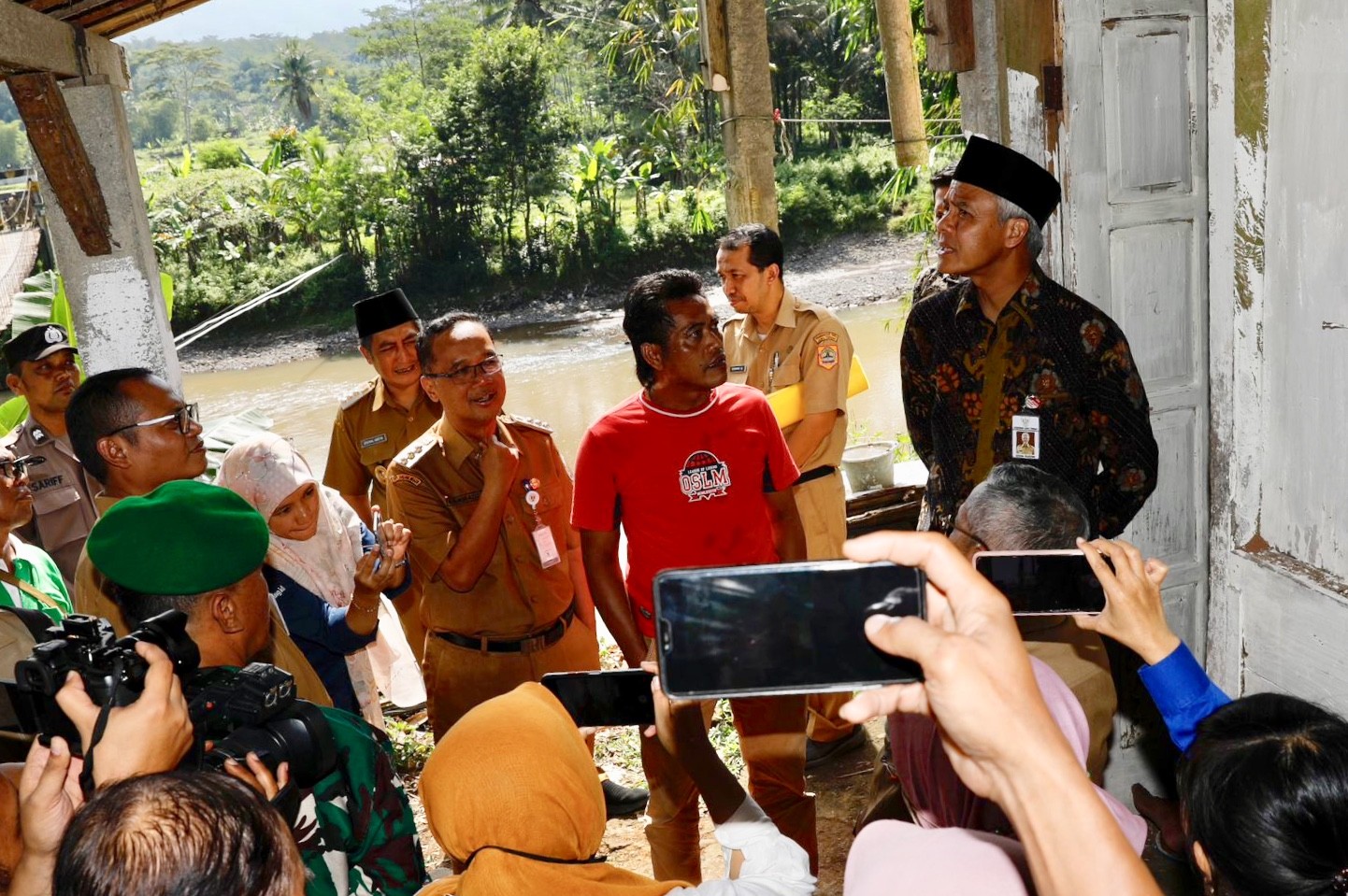Potret Gubernur Jawa Tengah Ganjar Pranowo saat berinteraksi dengan warga usai meninjau jembatan gantung yang berada di Kali Progo, Ngembik, Magelang, Senin (8/5/2023).