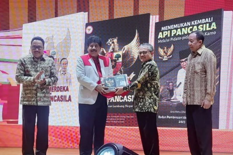 Kepala BPIP Yudian Wahyudi saat menyerahkan buku kepada Plt Kepala Perpusnas RI E. Aminudin Azis di Auditorium Perpusnas, Jakarta, Selasa (23/1/2024).