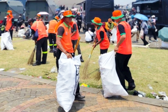 Petugas kebersihan saat membersihkan sampah di Monas usai acara perayaan HUT ke-80 TNI pada Minggu (5/10/2025).