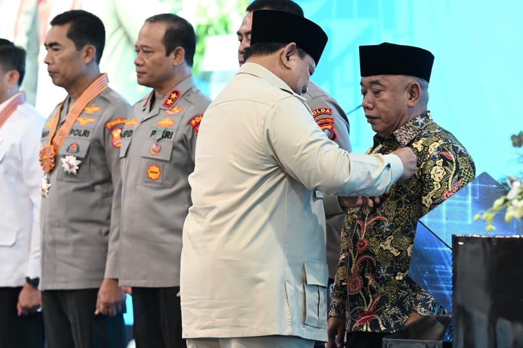 Presiden Prabowo saat memberikan anugerah tanda kehormatan ke sejumlah tokoh, di antaranya Zaini Sidi tokoh masyarakat asal Bekasi, saat peresmian 1.072 SPPG di SPPG Polri Palmerah, Jakarta, Jumat (13/2/2026).
