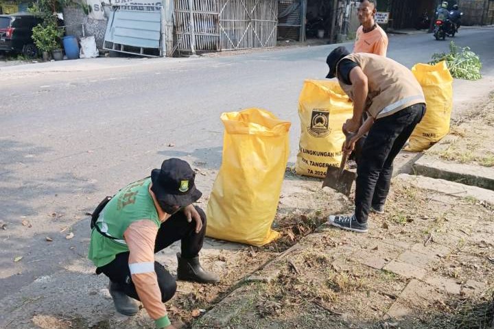 Petugas DLH Kota Tangerang saat membersihkan tumpukan sampah di jalan Marsekal Surya Darma.