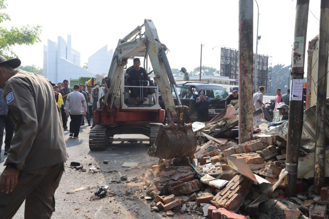 Proses penertiban 63 bangunan liar di Jalan Dipatiukur untuk mengembalikan fungsi trotoar dan saluran air.