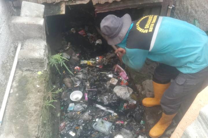 Petugas saat menormalisasi saluran air di Kebon Besar Tangerang, cepat tindak lanjuti laporan warga.